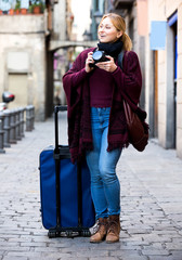 Obraz premium Girl holding camera in hands and photographing