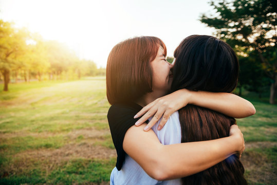 LGBT lesbian women couple moments happiness. Lesbian women couple together outdoors concept. Lesbian couple embraced together relation fall in love. Two asian women having fun together at park.