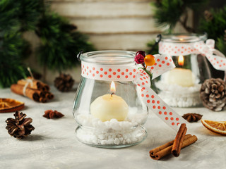 glass New Year candle holders with candles on a wooden white table, selective focus
