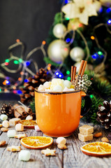 a cup of Christmas hot cocoa with marshmallow New Year's lights and decorations, selective focus
