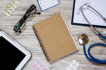 White wooden desktop with office and medical objects on it.