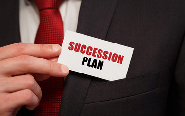 Businessman putting a card with text SUCCESSION PLAN in the pocket