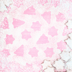 Christmas gingerbread pattern, top view, flat lay. Cookies covered with white icing and powdered sugar in pale pastel colors shaped as fir-tree and star. Pink wooden background