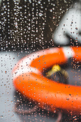 Orange life preserver on a boat during a rain storm, shallow depth of field