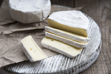 slices camembert cheese on the wooden plate 