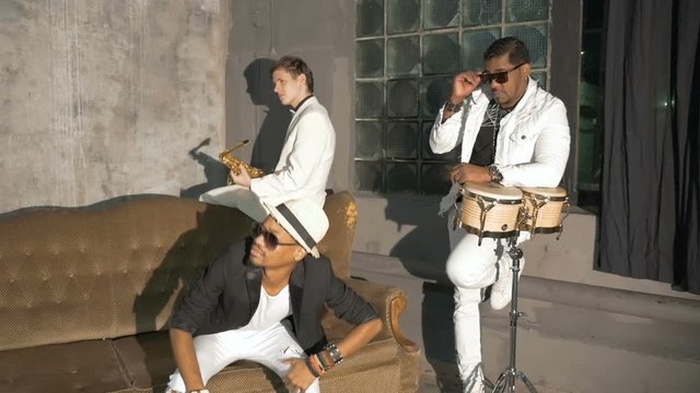 Three musicians participate in the filming of a music video.