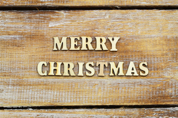 Merry Christmas written with wooden letters on rustic surface
