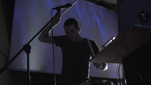 Club dj team scratching vinyl records on stage. hip hop djs playing music tracks on concert in the night club with drum sticks on pad. Dj scratch vinyl record. Beat maker play music on beat machine