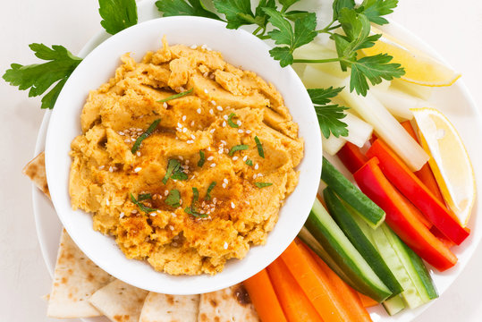 traditional sauce hummus with fresh vegetables and pita bread, closeup top view