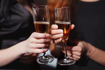 Beautiful girls in evening dresses with glasses of champagne to celebrate the New year