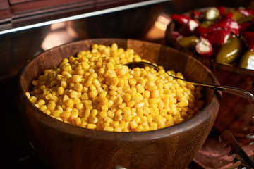 Sweet corn kernels in wooden bowl.