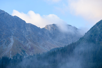 Fototapeta na wymiar mountain tops in autumn covered in mist or clouds