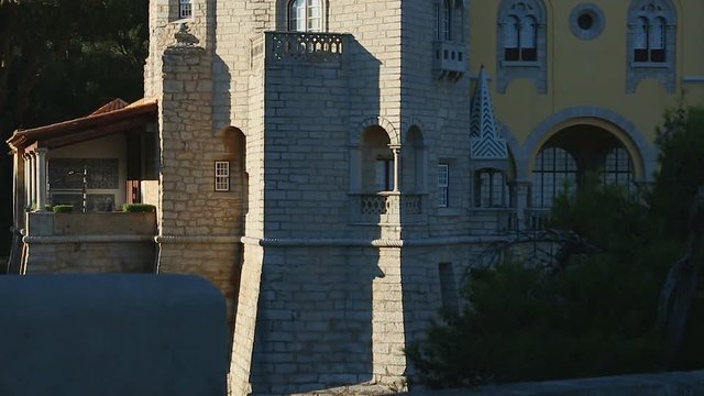 Castle-like house with tower in afternoon sunlight, famous architecture, tourism