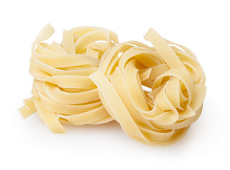 Uncooked nests of tagliatelle pasta isolated on white background with clipping path