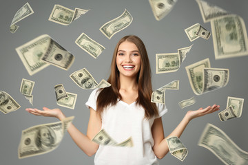 Young woman with money on grey background