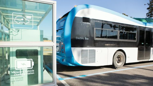 Electric bus stands at the charging station. His lights flash. 4K video