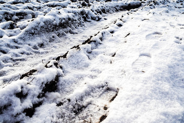 Car frozen earthen track on a bad road in the winter. The trail truck on a muddy impassable surface is covered with snow. Extreme driving on abandoned roads. 