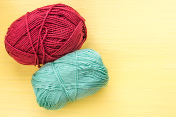 two balls of yarn close up on a yellow background