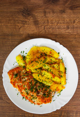 Grilled chicken breast with potato in a plate on a wooden background. with copy space. top view