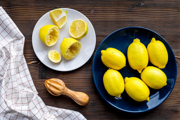 Wooden juicer for making lemonade on dark wooden background top view