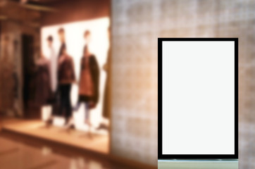 vertical advertising billboard or blank showcase light box for your text message or media content in front of fashion women clothes shop showcase in shopping mall, sale, commercial and marketing