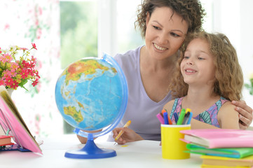 mother helping her  daughter with homework