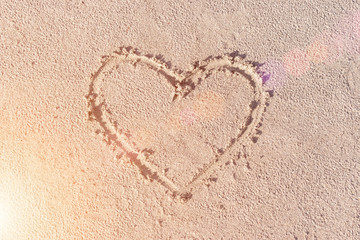 Heart drawn in the sand. Beach background. Top view. Sunny.