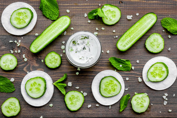 Cucumber moisturising cream or mask pattern. Dark wooden background top view
