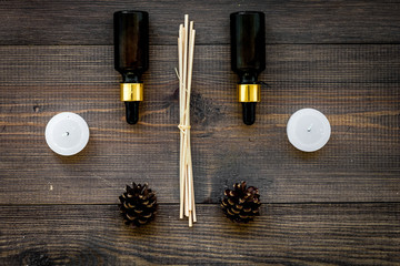 Skin care and relax. Cosmetics and aromatherapy concept. Pine oil on dark wooden background top view