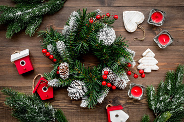 Fototapeta na wymiar Christmas decorations. Wreath and toys on wooden background top view