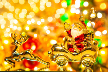 Fototapeta premium Santa Claus with gifts on car with christmas deer,on bokeh background