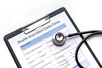 Health insurance for reception at the doctor. Document, stethoscope, pad on white background top view