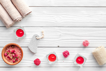 Romantic set for foot spa. Candles, salt, pumice stone, soap on white wooden background top view copyspace