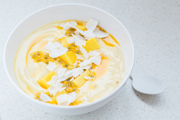 Mango smoothie bowl with coconut and passion fruit.