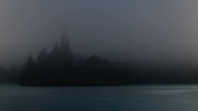 Bled Lake Island in the Fog in a Winter day with Iced Lake. UHD 4K TimeLapse. Bled lake its castle and iconic island with church is a Slovenia iconic place with terme and hotel. Bled 5 February 2017.