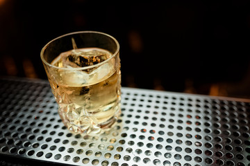 Beautiful cocktail photo served on the bar dark background drink