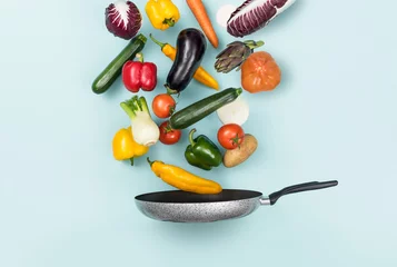 Poster Fresh healthy vegetables falling in a pan © stokkete