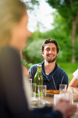 Group of young people having fun outside, focus on a young man