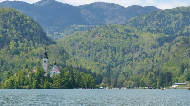 Bled Lake Island with Church. Hyperlapse in 4K UHD. Bled lake its castle and island with church is a Slovenia iconic place with terme and hotel. Tourists can rowing, boating and camping in the Alps