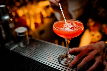 Delicious red cocktail on dark background bar party