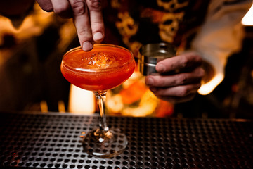 Delicious red cocktail on dark background bar party