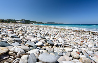 Fototapeta na wymiar Pebble beach with clear blue water on Rhodes island, Greece