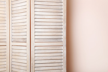 Wooden folding screen on a beige background
