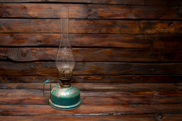 Old retro oil kerosene lamp on a wooden background