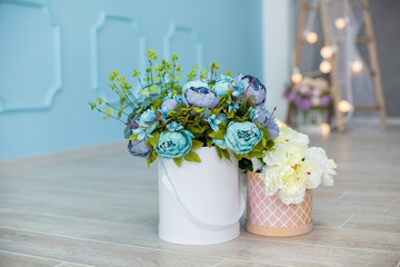 Studio interier decoration with flowers in light warm colors and casual vintage furniture