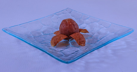 One peeled medlar on a glass platter,close up
