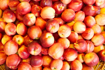 Fototapeta na wymiar Nectarines in the store. A lot of nectarines close-up. Ripe nectarines. Selective focus 