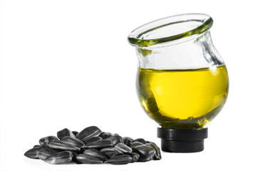 Sunflower seeds and sunflower oil in a round glass jar isolated on a white background.