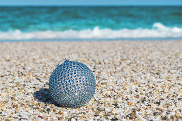 Christmas ball in the sand on a tropical beach