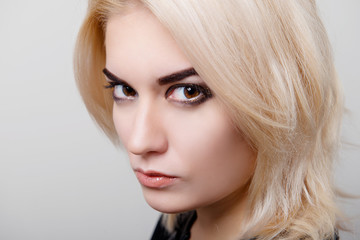 Blonde girl with bright makeup and clean skin on a white isolate close-up